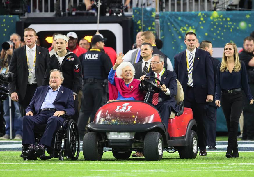 L&#39; ex presidente George H.W. Bush e la moglie Barbara vengono portati in campo per l&#39;avvio della partita (Reuters)